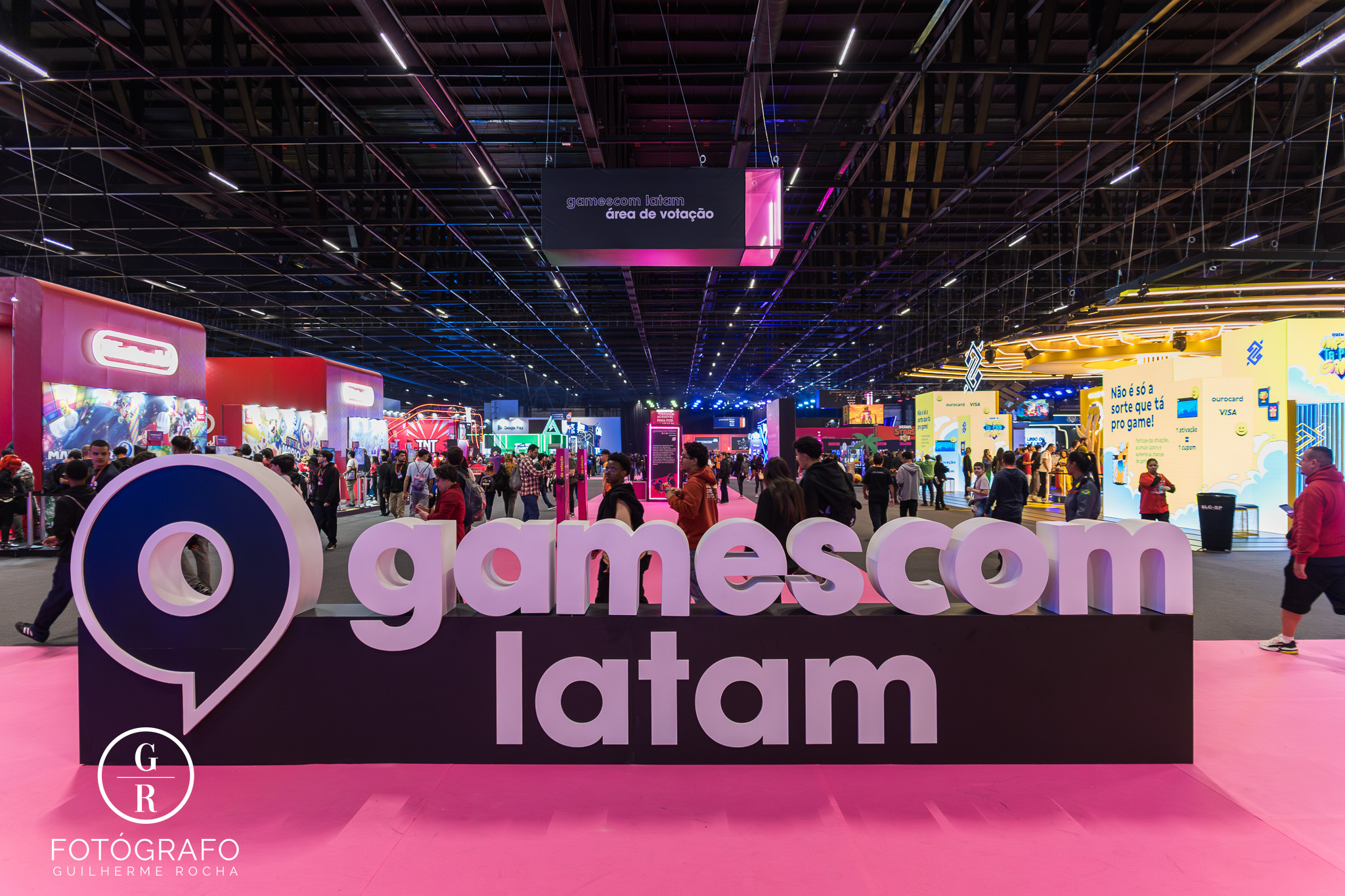 Brindes mais disputados da Gamescom Latam 2025 em destaque no pavilhão principal, com estandes iluminados e grande movimentação de visitantes.