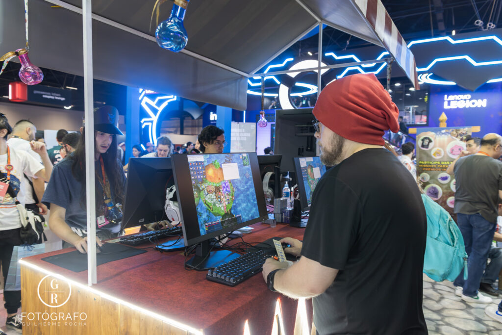 Gravity na Gamescom Latam oferece estações com computadores para testar Ragnarok, com visitantes jogando no estande.