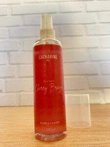 Catharine Hill body splash Cherry Breeze com fragrância Bubble Cherry, frasco cilíndrico de 200 ml em tons de vermelho e tampa transparente, sobre fundo branco.