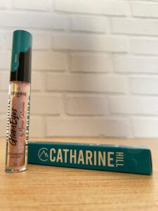 Catharine Hill delineador em gel com efeito cintilante, embalagem transparente com tampa preta e turquesa, acompanhado da caixa retangular azul com logo em branco.