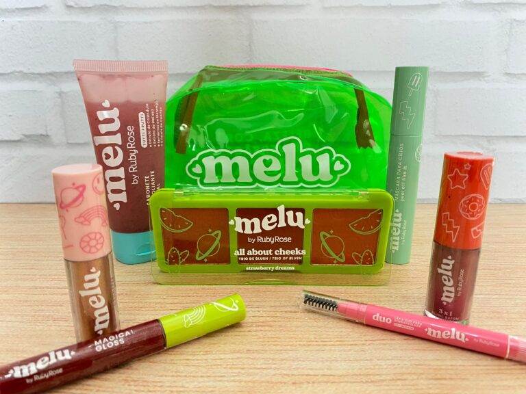 Ruby Rose apresenta a linha Melu na Beauty Show 2025: nécessaire verde vibrante com trio de blush all about cheeks, gloss labial, máscara para cílios, balm multifuncional, sabonete facial e lápis duo para sobrancelhas.