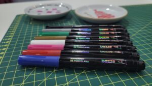 Tris apresenta marcadores da linha Bazze voltados para porcelana, com ponta precisa e várias cores vibrantes, ideais para pintura em cerâmica, vidro e superfícies lisas.