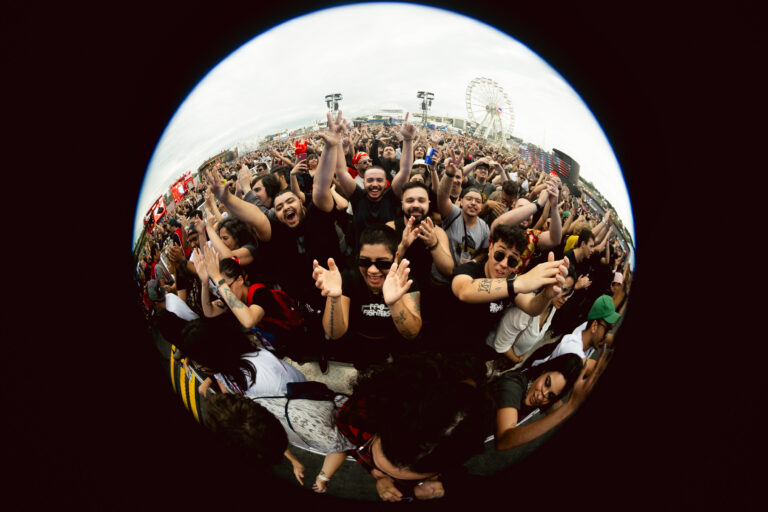 The Town 2023 reúne multidão vibrante em frente ao palco principal, capturada com efeito olho de peixe que destaca a energia do público e a roda gigante ao fundo.