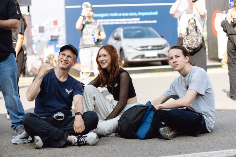 The Town proporciona momentos de descanso e descontração entre shows; grupo de amigos sentados no chão aproveita o clima leve e acolhedor do festival em São Paulo.