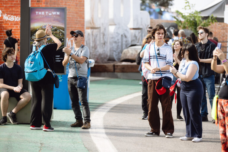 The Town recebe visitantes de todas as idades que exploram o espaço do festival; público consulta mapa de atrações e aproveita a estrutura do evento durante o dia.