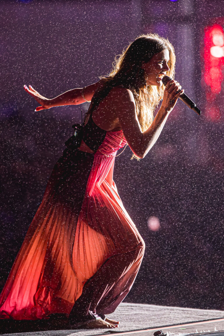The Town emociona com Joss Stone cantando descalça sob chuva no palco Skyline; cantora britânica se destaca com vestido fluido em tons de rosa e performance intensa.