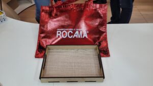 Rocama apresenta sacola promocional vermelha com logotipo estampado durante a Mega Artesanal 2025.