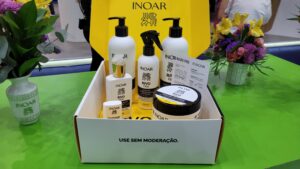 Linha RivoFios da Inoar em destaque, com kit antifrizz completo exposto em caixa branca no estande da Beauty Fair 2025.