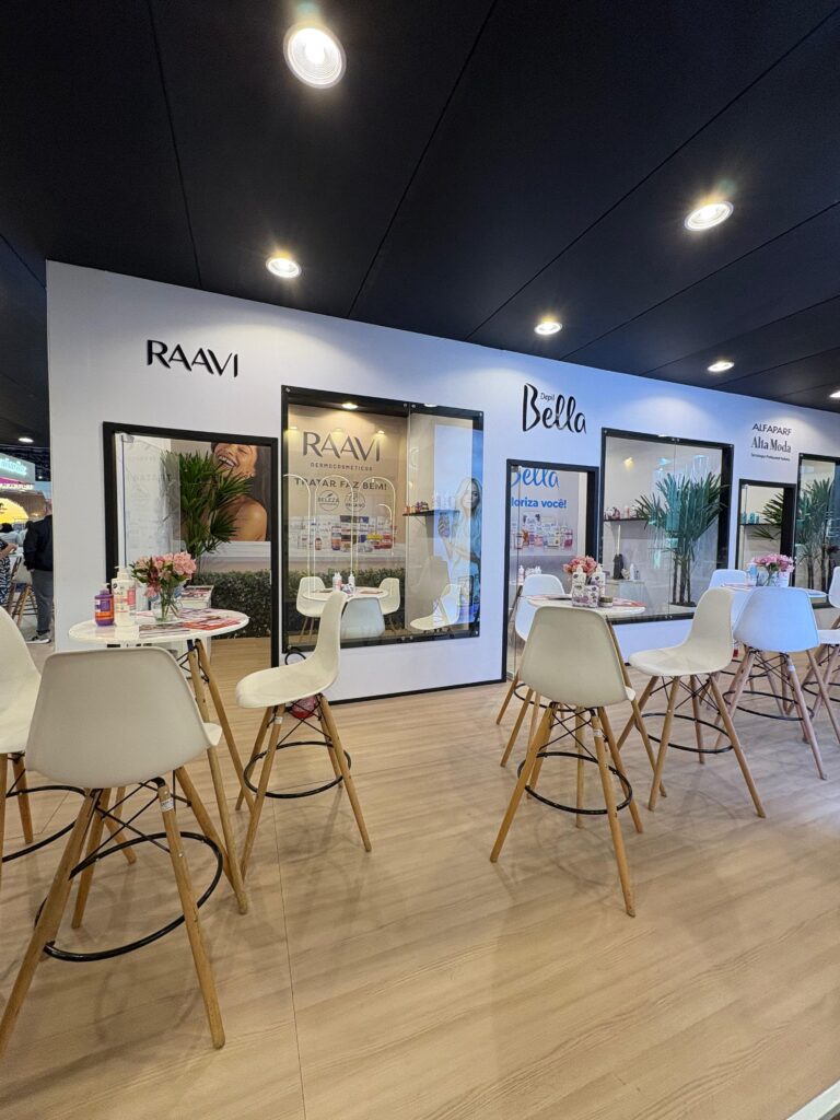 Estande da Depil Bella e Raavi na Beauty Fair 2025 com mesas de atendimento, produtos expostos e espaço de interação com visitantes.