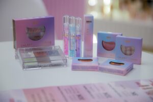 Coleção Galaxy da Nina Makeup com paleta de sombras, gloss, iluminador e blush apresentada como futuro lançamento na Beauty Fair 2025.