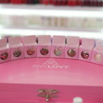 Caixa com glitters decorativos Any Lovy em diversas cores e formatos para nail art profissional.