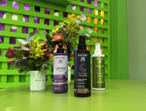 Lançamentos da Inoar: máscara Lamelar de ação rápida, tratamento noturno Overnight e Óleo em Creme de argan, apresentados em estande decorado com flores.