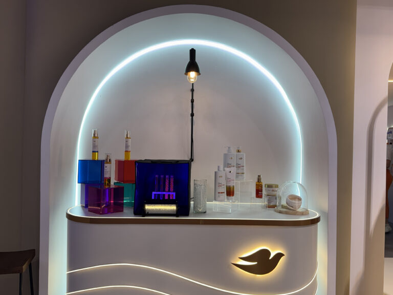 Área premium da Dove na Beauty Fair 2025 com destaque para séruns, shampoos e itens de cuidados pessoais em exposição iluminada.