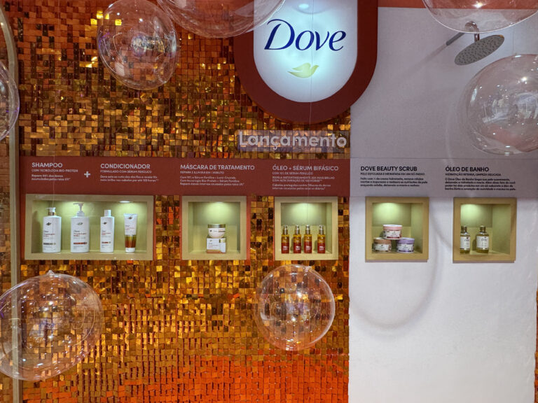 Lançamentos Dove na Beauty Fair 2025 em exposição, incluindo shampoo, condicionador, máscara, sérum bifásico, scrubs corporais e óleo de banho.