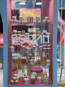 Produtos da linha Ice Cream Gourmand Poran organizados em vitrine no estande da marca durante a Beauty Fair 2025.