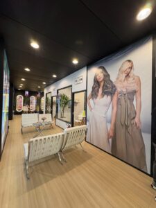 Corredor do estande da Alfaparf na Beauty Fair 2025 com painéis visuais, espaço de convivência e exposição de linhas profissionais de cabelo.