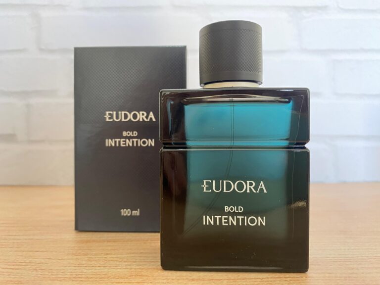 Perfume masculino Eudora Bold Intention em frasco azul escuro com caixa ao fundo.