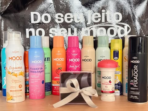 Linha completa MOOD exposta em bancada com sprays, desodorantes, espuma corporal e fixadores, recebidos na Beauty Fair 2025.