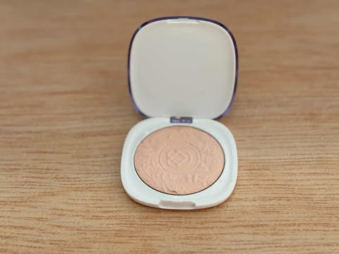 Pó iluminador compacto Dalla aberto exibindo textura e relevo.
