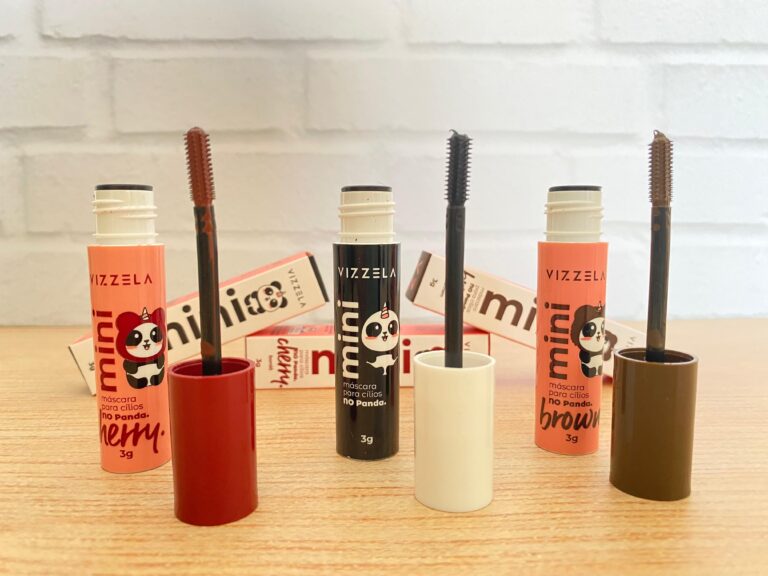 Três máscaras de cílios Vizzela Mini No Panda nas cores Cherry, Black e Brown abertas sobre mesa de madeira, destacando o aplicador e embalagem divertida.