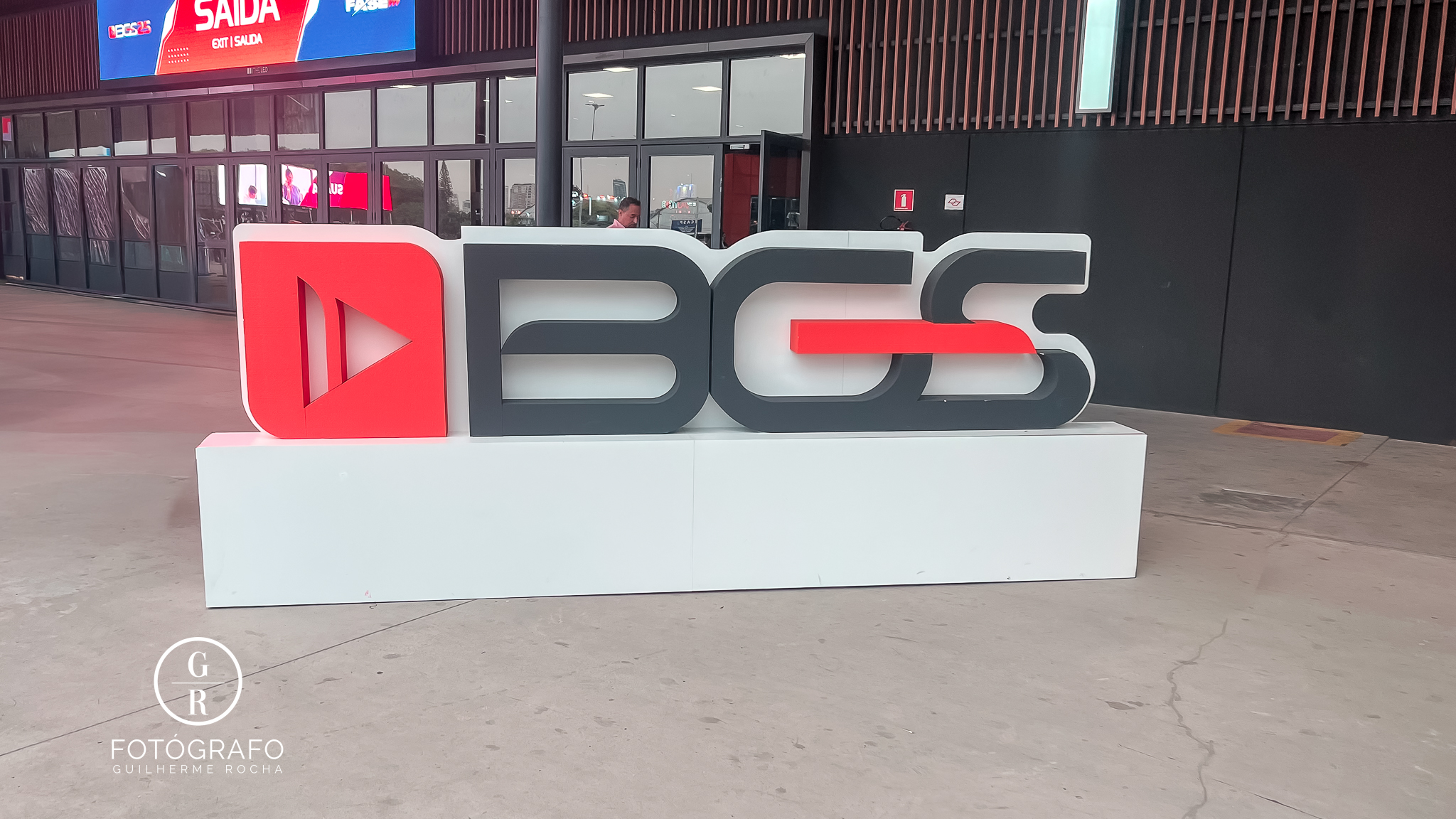 Logo da BGS 2025 em frente à entrada do evento, com letras em preto e vermelho, representando a Brasil Game Show.
