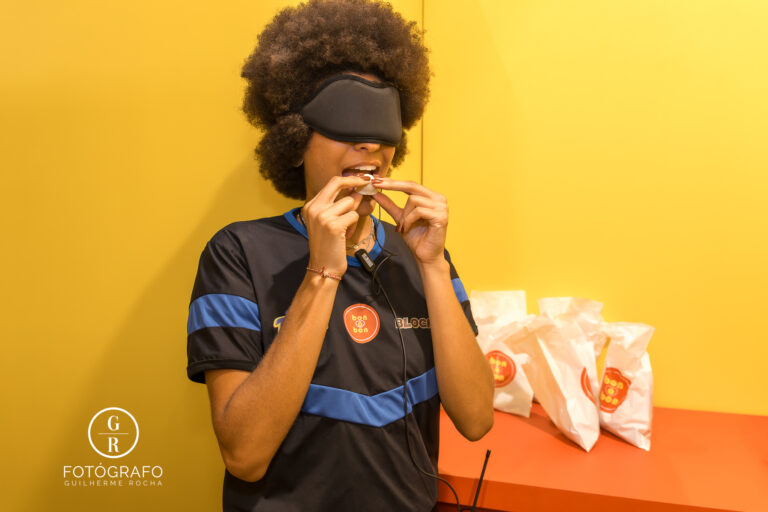 Participante experimenta chocolate da marca Arcor com os olhos vendados durante a ativação sensorial de Bon o Bon na BGS 2025, destacando a experiência interativa da marca.