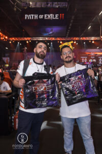 Visitantes exibem ecobags oficiais de Path of Exile 2 com o logo do jogo e da BGS 2025, após participarem das ativações no estande.