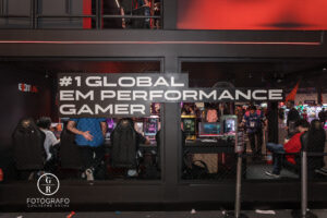 Estande da ExitLag na BGS 2025 com o painel #1 Global em Performance Gamer e visitantes testando computadores no espaço interativo.