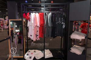 Loja da ExitLag na BGS 2025 com camisetas, shorts e uniformes gamer expostos em araras, destacando o design moderno da marca.