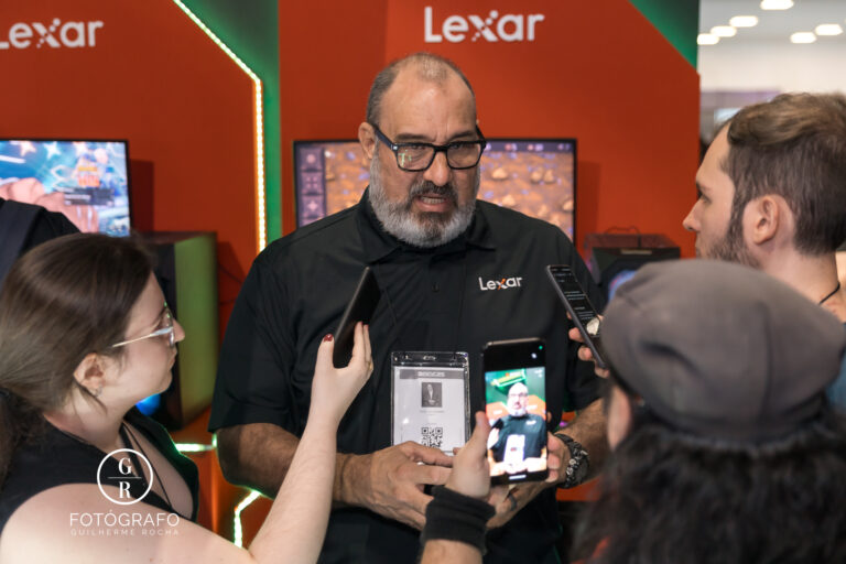 Representante da Lexar concede entrevista durante a BGS 2025, cercado por jornalistas e criadores de conteúdo no estande da marca.
