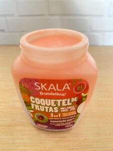 Máscara Skala Frutástica Coquetel de Frutas aberta, com creme rosado de melancia, coco e uva voltado para hidratação dos fios.