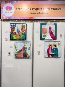 Painel da Exposição Art Quilt: Natal Tropical na Criativa Campinas, com quilts coloridos inspirados no clima tropical e no Natal.
