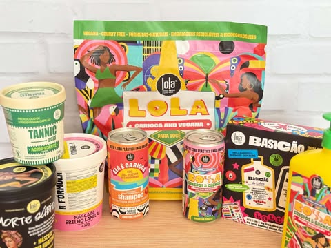 Kit Lola com várias embalagens vibrantes da Lola Cosmetics organizadas para foto de recebidos, destacando máscaras, shampoos e itens veganos da marca.