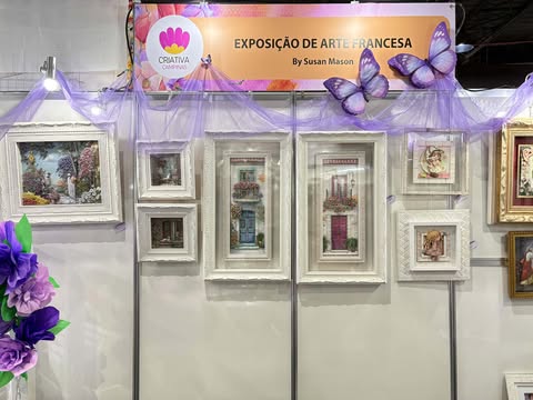 Painel central da Exposição de Arte Francesa na Criativa Campinas, com quadros em molduras brancas e detalhes roxos na decoração.