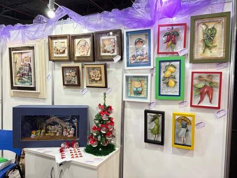 Quadros em arte francesa expostos na Criativa Campinas, com trabalhos tridimensionais coloridos e uma pequena árvore natalina decorada.