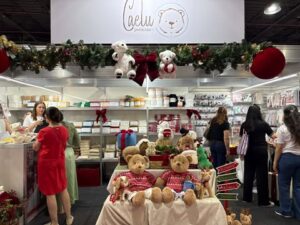 Estande da Caelu Pelúcias na Criativa, decorado com tema natalino e diversos ursinhos de pelúcia expostos para os visitantes.