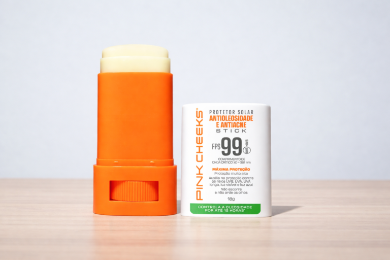Protetor solar stick FPS 99 da Pink Cheeks antioleosidade e antiacne, com embalagem branca e laranja, acabamento matte e formato prático para reaplicação diária.