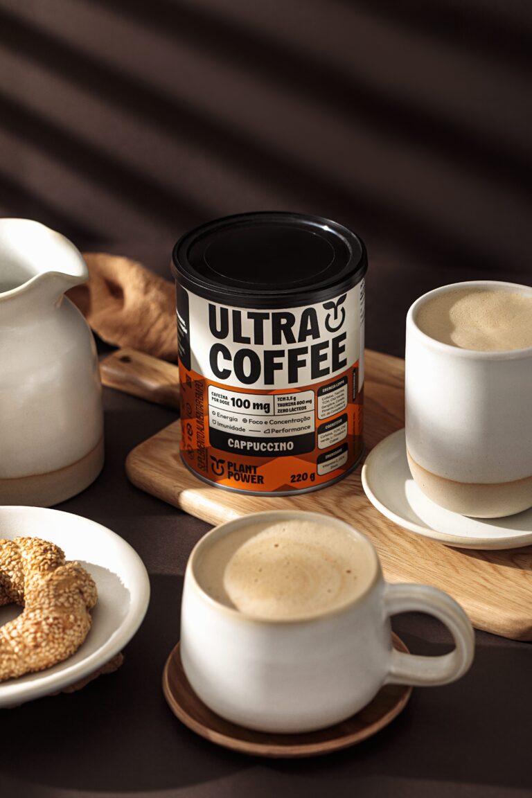 Ultracoffee da Plant Power em embalagem sabor Cappuccino sobre mesa com xícaras de café, destacando suplemento para foco, energia e produtividade no dia a dia.