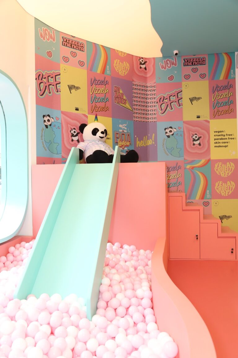 Escorregador da flagship da vizzela em São Paulo, com panda decorativo e paredes estampadas com identidade visual da marca.
