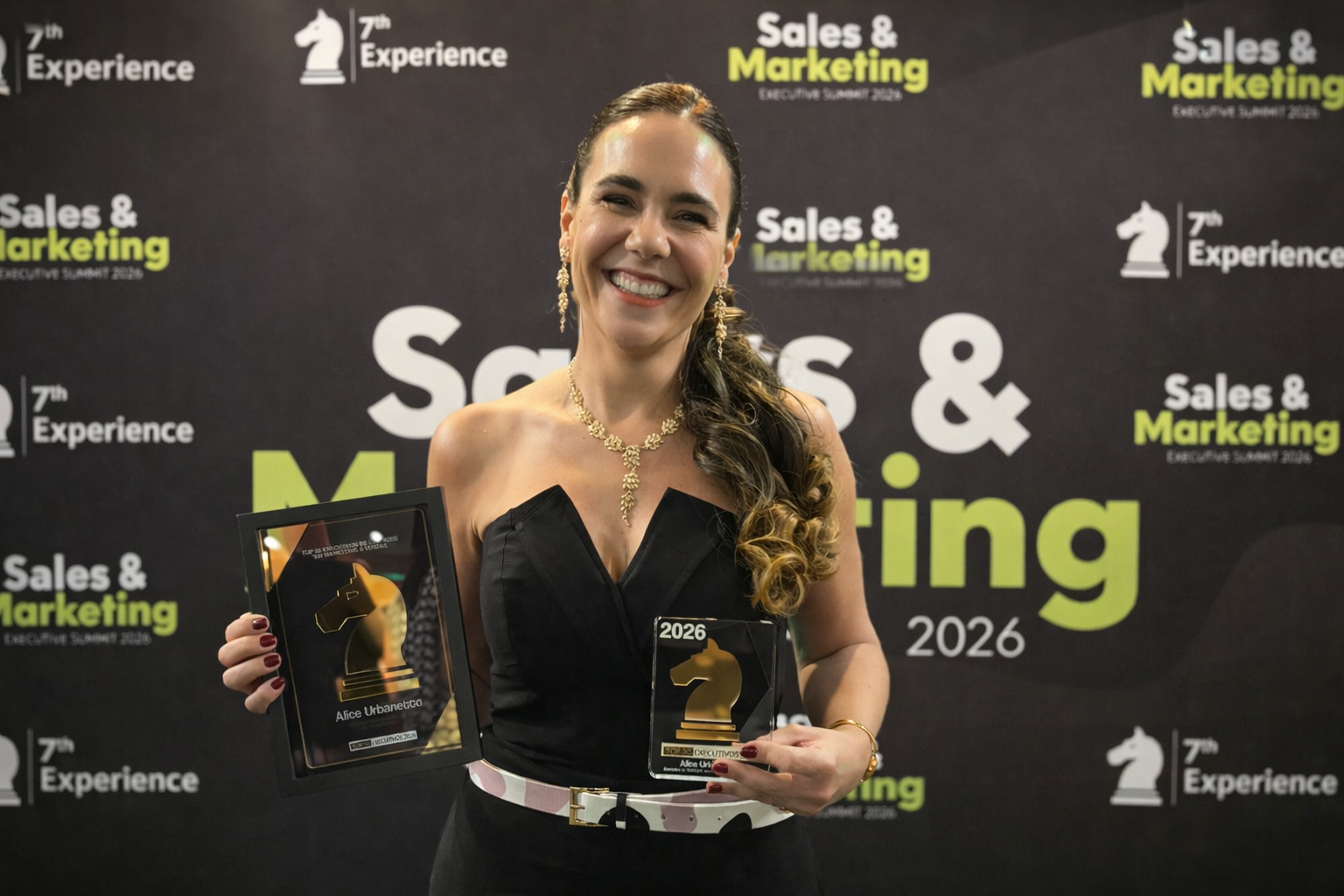 Executiva Alice Urbanetto, CMO da Milky Moo, posa com prêmios durante o Sales & Marketing Executive Summit 2026, destacando reconhecimento no setor de marketing.