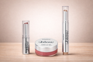 Produtos labiais ruby rose Blow com balm to go e batom em destaque em embalagem prateada sobre mesa de madeira