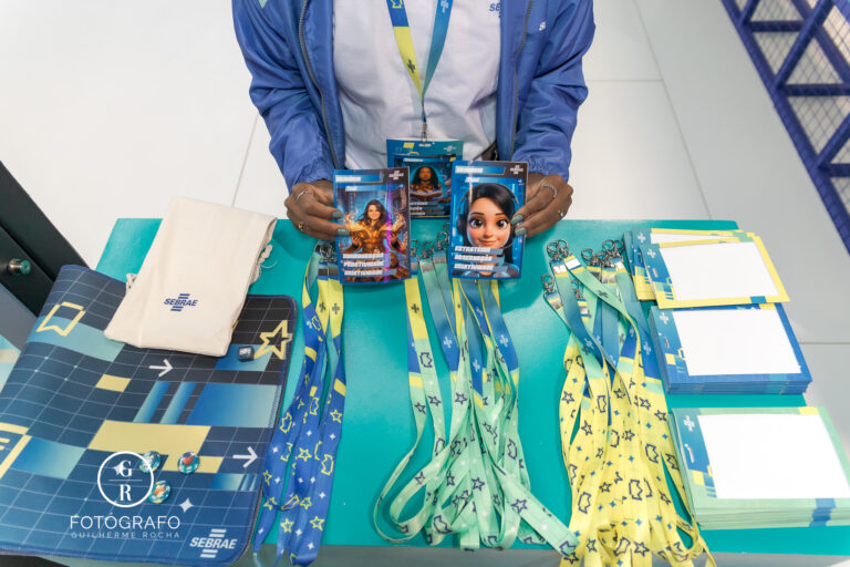 Itens do Sebrae com crachás personalizados, pins e brindes organizados no estande durante a gamescom latam.