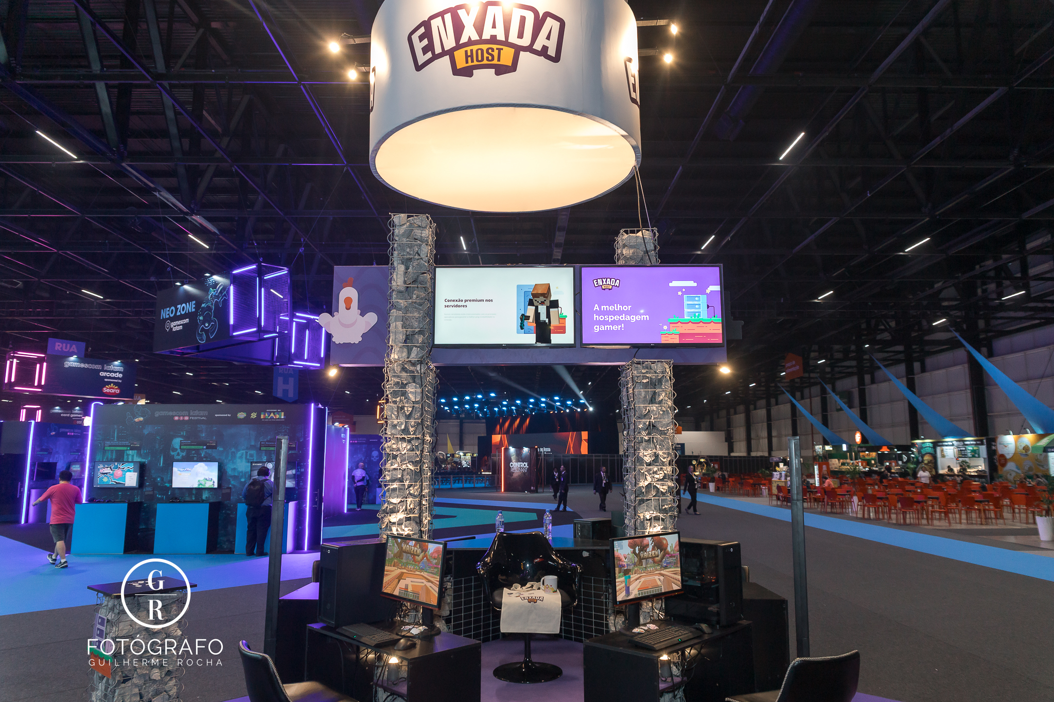Estande enxada host na gamescom com computadores para jogar Minecraft e testar serviço de hospedagem gamer