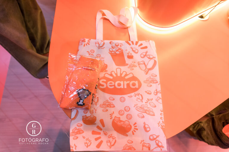 Ecobag e meia promocional da Seara exibidas no estande com identidade visual temática de alimentos.