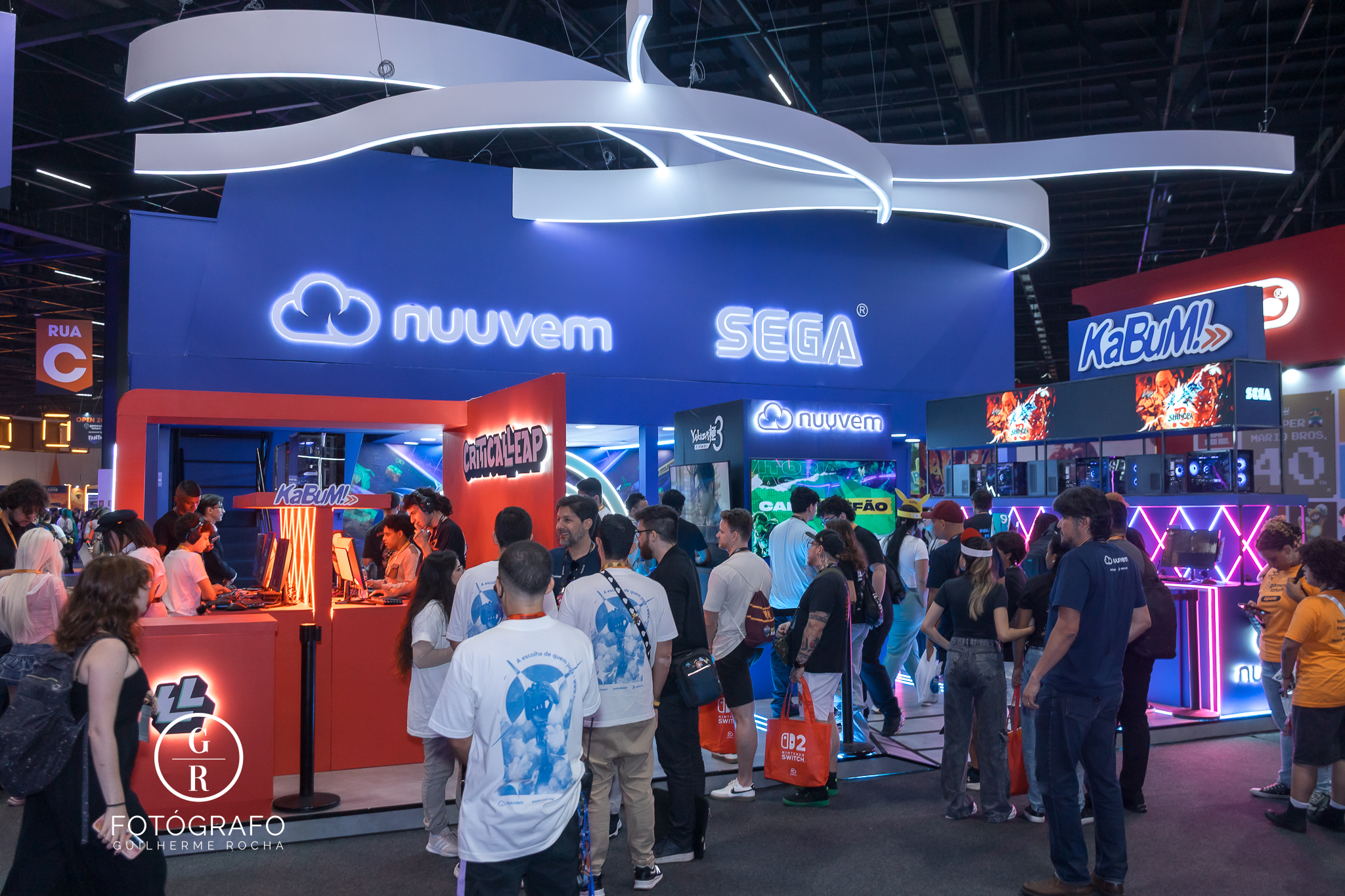 Visão geral do estande da Nuuvem em parceria com a Sega, com grande fluxo de visitantes na Gamescom.