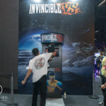 visitante testa máquina de soco no estande com temática espacial durante a gamescom