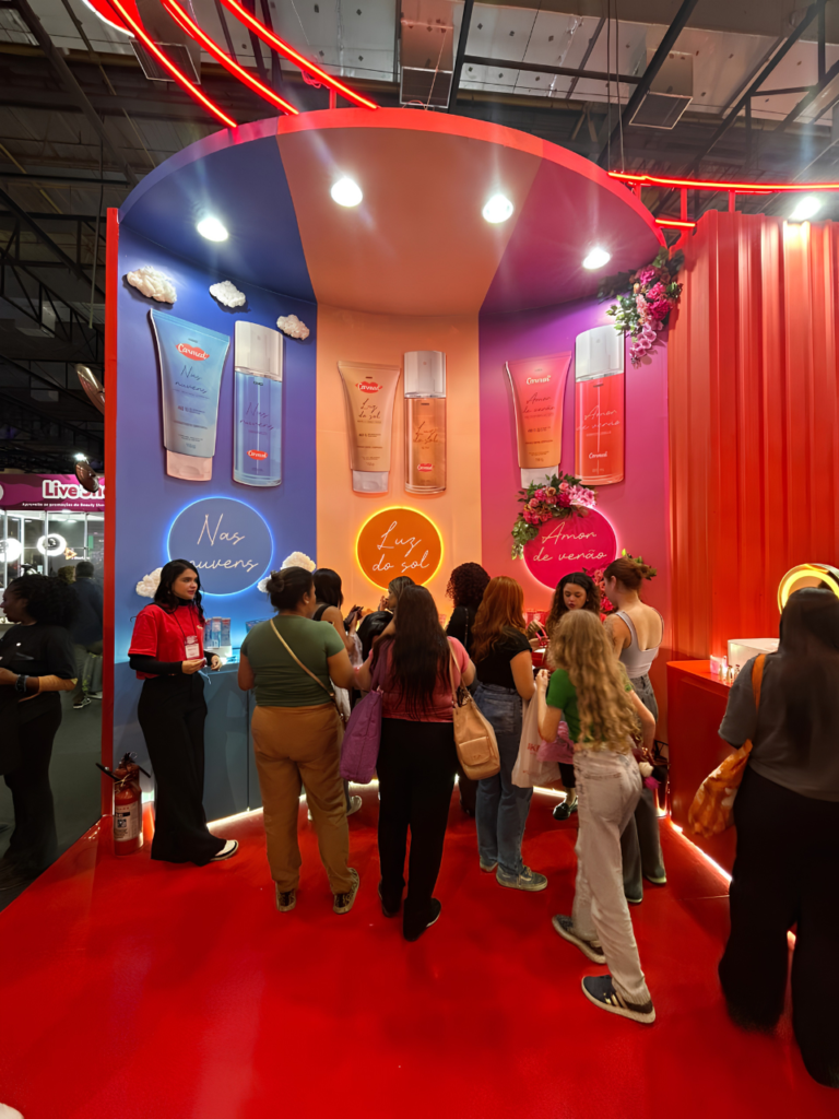 Consumidores participam da experiência promovida pela Carmed na Beauty Show, explorando as fragrâncias da linha de body splashes em um espaço temático e instagramável.