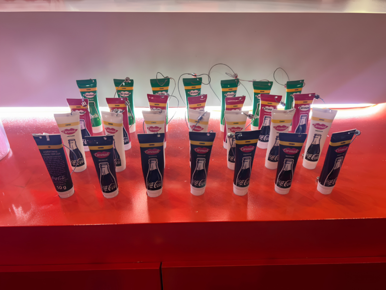 Produtos Carmed personalizados em formato de chaveiro são exibidos no estande da marca, reforçando a proposta de customização apresentada durante a Beauty Show.