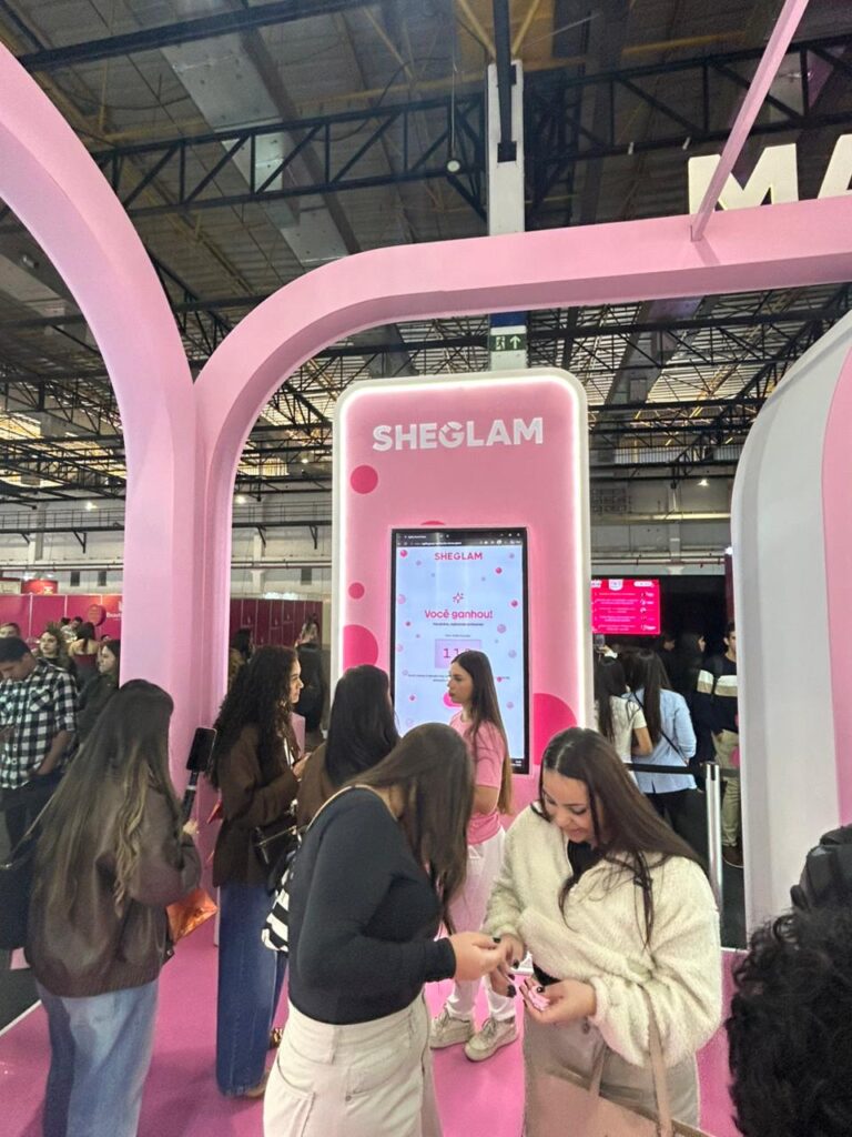Participantes interagem com ativação digital da Sheglam, que distribuiu brindes e promoveu experiências exclusivas no estande da marca.