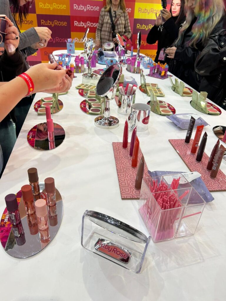 Visitantes experimentam produtos da Ruby Rose em área interativa com espelhos, maquiagens coloridas e lançamentos inspirados em tendências de beleza e autocuidado.